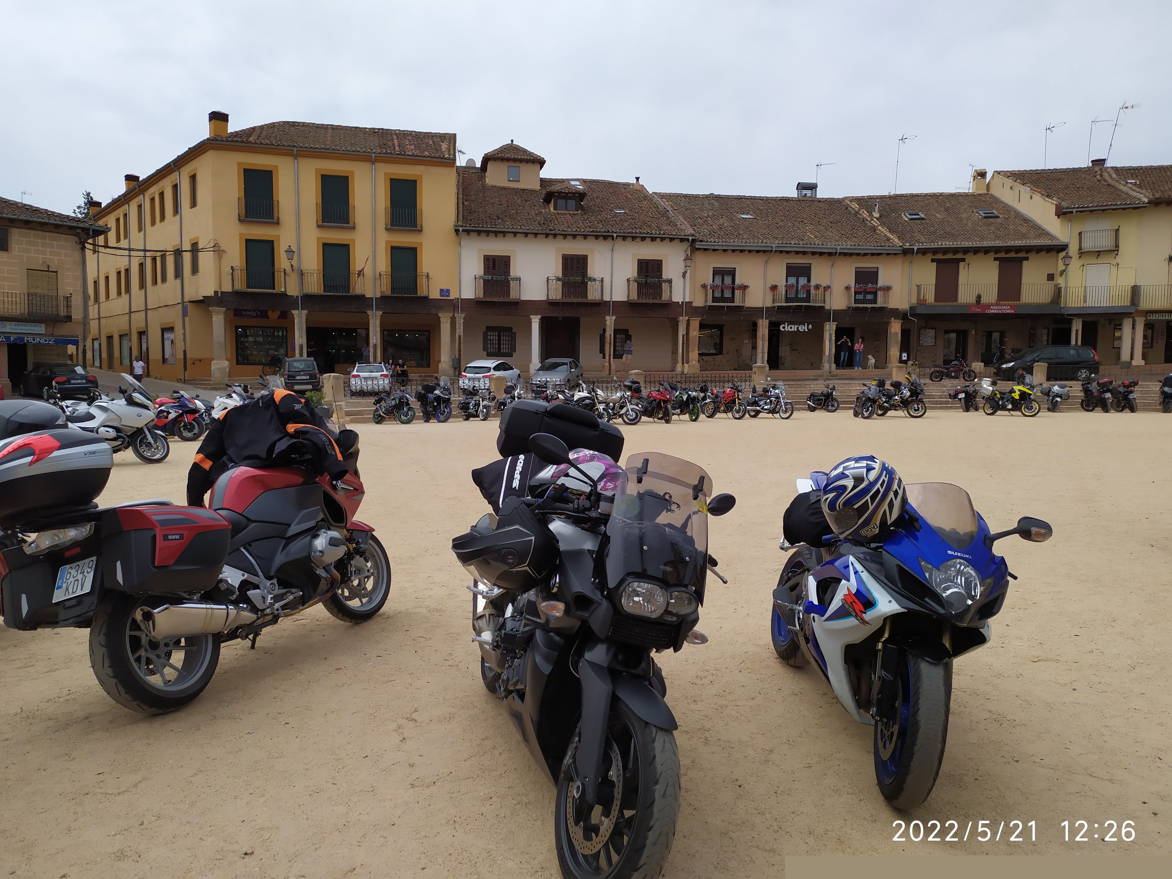 Motos aparcadas en plaza de tierra, diferentes modelos