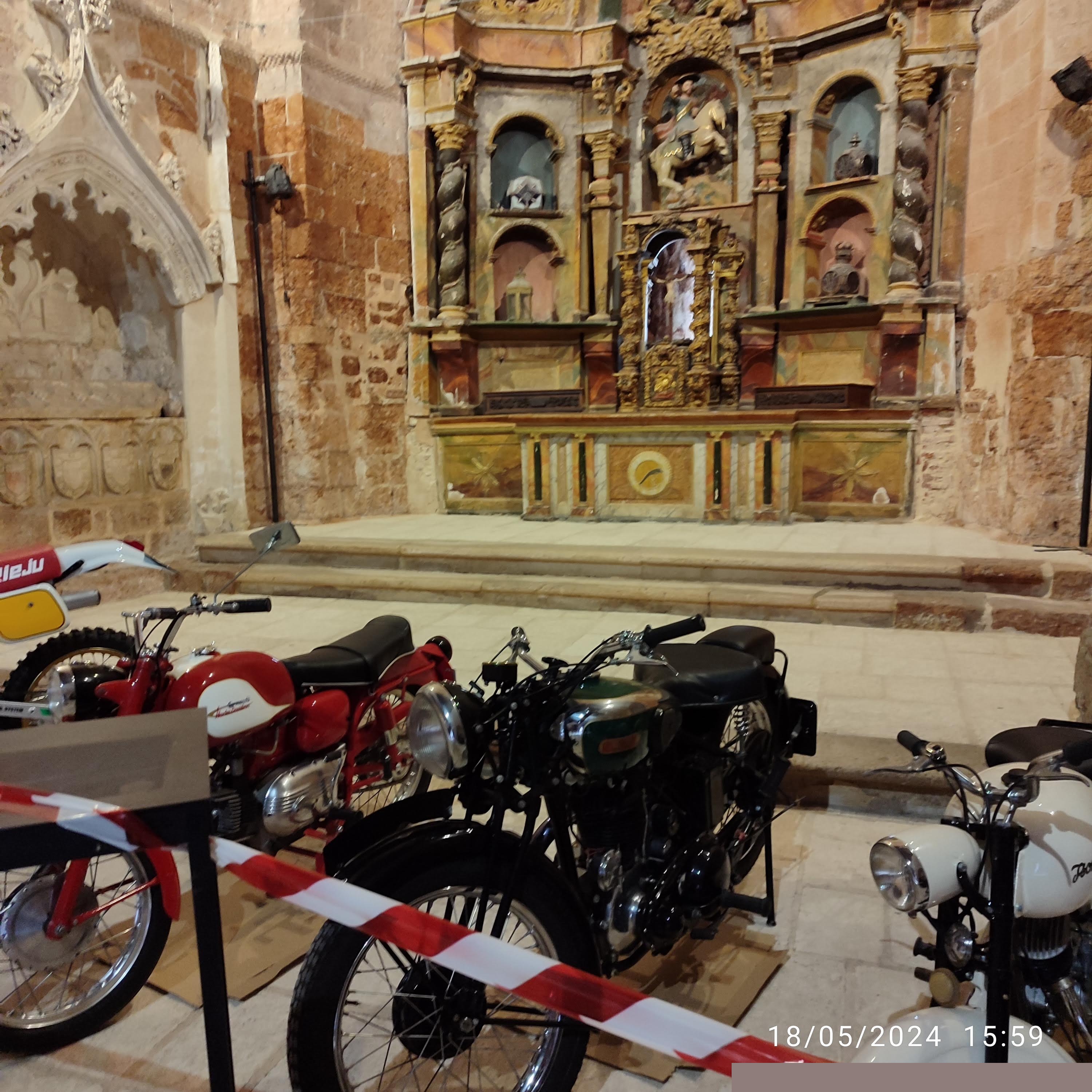 Exposición de motos clásicas y vintage en el interior de una iglesia histórica