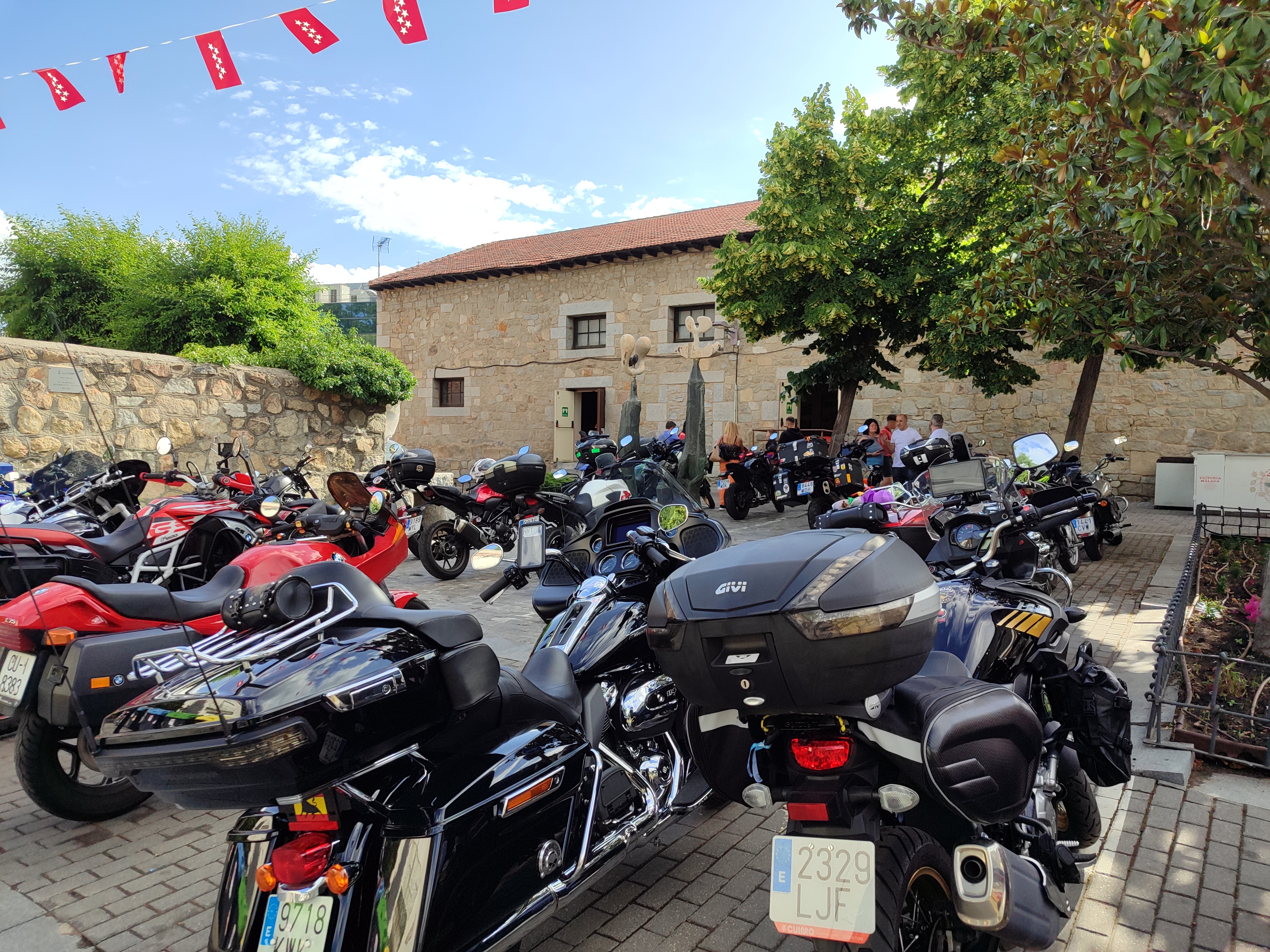 Motos aparcadas en plaza de piedra durante la concentración de San Antonio de Padua en Collado Villalba